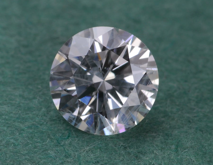 A round diamond resting on a green surface