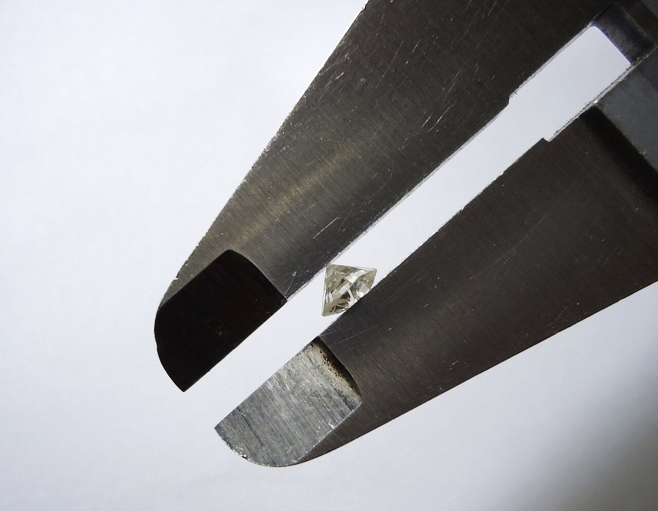 A diamond held between the jaws of a measuring caliper